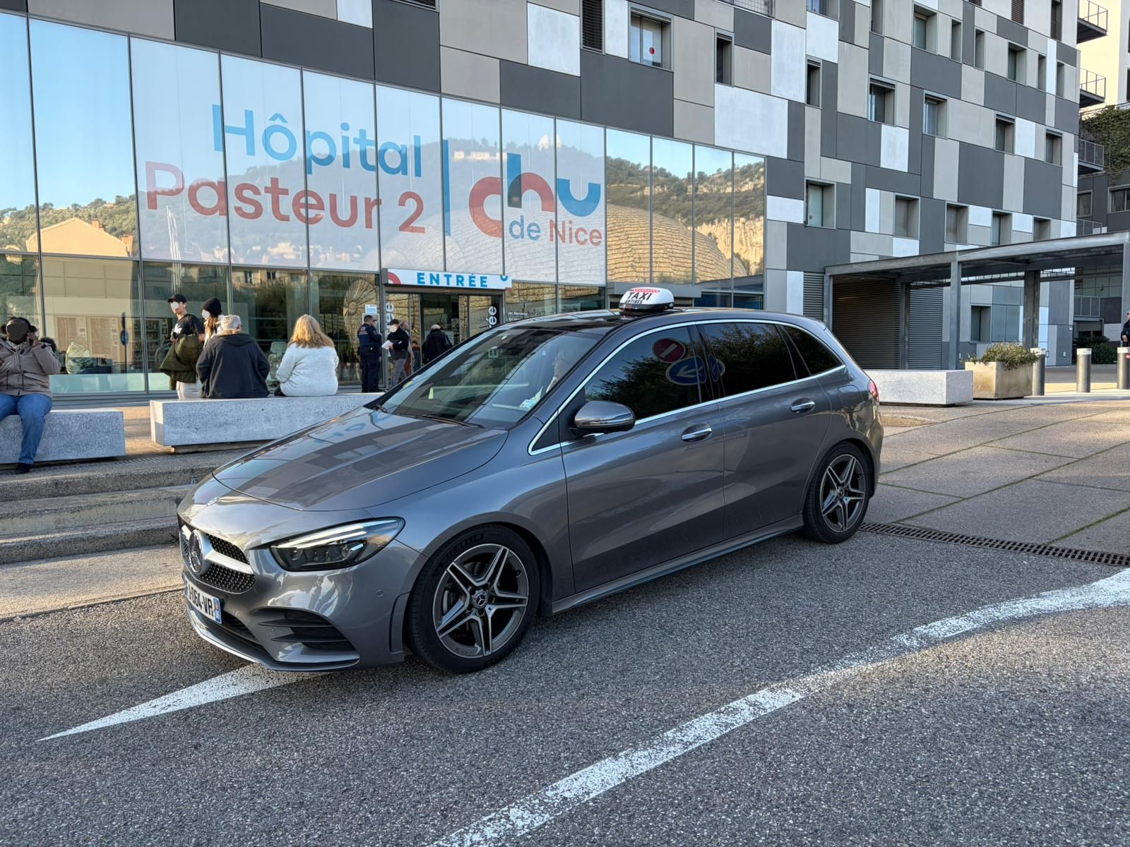 Taxi Cagnes-sur-Mer vers Hôpital Pasteur — véhicule Tesla conventionné CPAM devant l’Hôpital Pasteur du CHU Nice, transport médical depuis Cagnes-sur-Mer